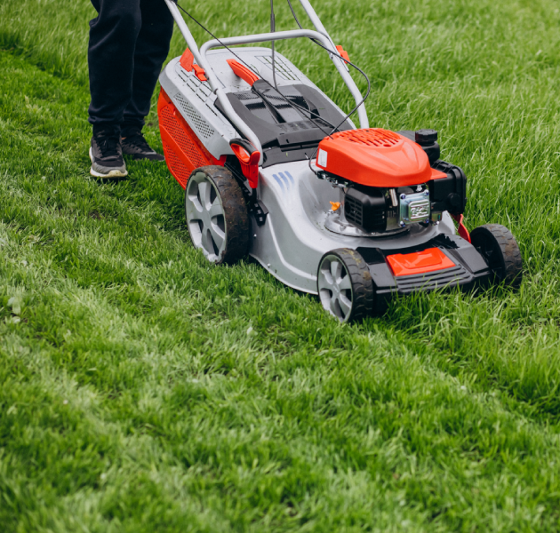 Man cutting grass with lawn mover in the back yard<br />